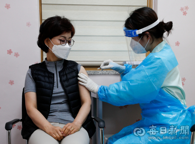 대구경북 650개 요양병원.재활시설 종사자와 65세미만 입소자 3만2천명에 대한 코로나19 백신 1차 접종이 지난달 26일 각 구.군 보건소와 자체 접종이 가능한 요양병원에서 시작됐다. 이날 오전 대구 중구보건소에서 대구 지역 요양시설 1호 접종자인 사회복지사 김혜원 씨가 접종을 받고 있다. 우태욱 기자 woo@imaeil.com