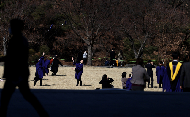 26일 서울 관악구 서울대학교 본관 앞 잔디광장에서 졸업생들이 기념사진을 찍고 있다. 신종 코로나바이러스 감염증 확산으로 이날 서울대 학위수여식은 온라인 실시간 재생 방식으로 열렸다. 연합뉴스