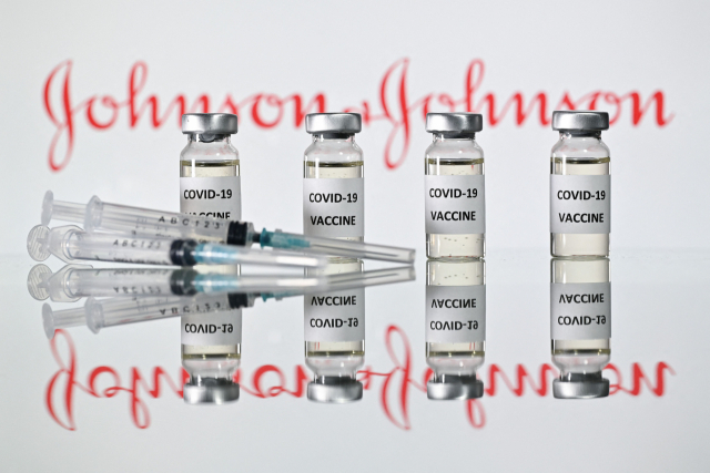 미국 식품의약국(FDA)이 2월 27일(현지시간) 자국 제약사 존슨앤드존슨(J＆J)의 신종 코로나바이러스 감염증(코로나19) 백신에 대해 긴급사용을 승인했다고 AP통신 등 현지 언론이 보도했다. 이로써 미국은 화이자-바이오엔테크와 모더나에 이어 세 번째 코로나19 백신을 확보하게 됐다. 사진은 존슨앤드존슨사의 로고 앞에 놓인 코로나19 백신과 주사기의 모습. 연합뉴스