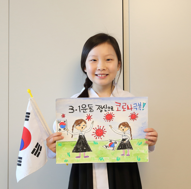 독립운동가 장진홍 의사의 현손녀인 장예진 양이 코로나 극복 염원을 담은 그림을 들어보이고 있다. 칠곡군 제공