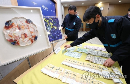 서울시 38세금징수과 직원이 3일 서초구 양재동 최순영 전 신동아그룹 회장 자택에서 압수한 현금과 미술품을 시청 브리핑룸에서 공개하고 있다. 시는 이날 납세자의 날을 맞아 최 전 회장 자택을 수색, 현금 2천687만원과 미술품 등 동산 20점을 압류했다. 최 전 회장은 세금 38억9천만원을 체납하고 있다. 연합뉴스