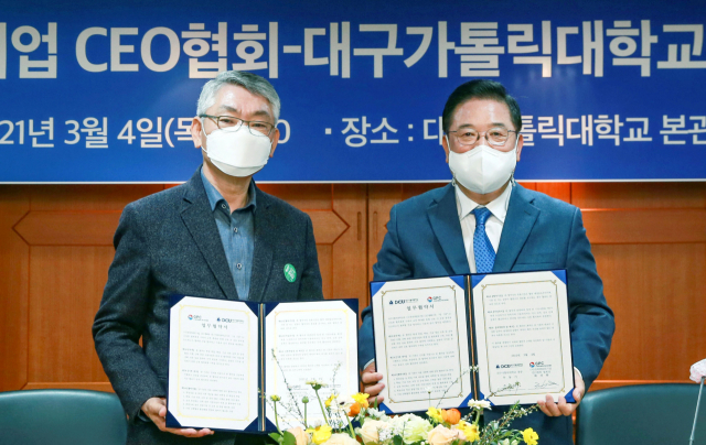 우동기(오른쪽) 대구가톨릭대 총장과 배선봉 (사)경북PRIDE기업 CEO협회장이 협약서를 들어보이고 있다. 대구가톨릭대 제공