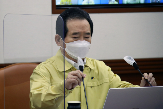 정세균 국무총리가 5일 오전 정부서울청사에서 열린 신종 코로나바이러스 감염증(코로나19) 대응 중앙재난안전대책본부(중대본) 회의를 주재하기 전 마이크를 조정하고 있다. 연합뉴스