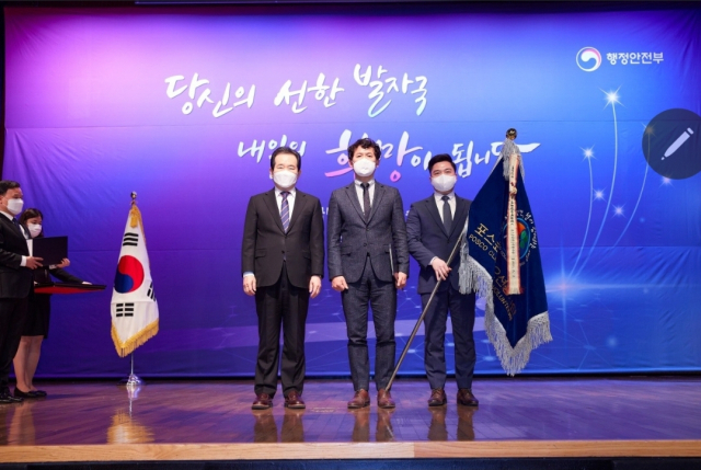 정세균 국무총리(왼쪽)와 이상길 포항클린오션봉사단장(가운데), 배재혁 사무국장(오른쪽)이 표창 후 기념촬영을 하고 있다. 포스코 제공