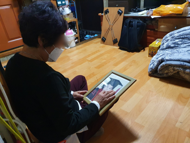 유순애(가명·65) 씨가 어린시절 딸의 사진을 바라보고 있다. 순애 씨는 그 시절이 너무 그립다. 배주현 기자