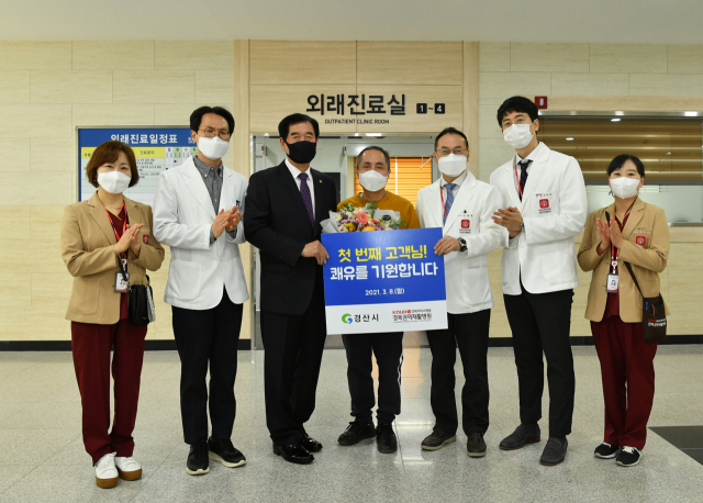 경북권역재활병원이 8일 첫 외래진료를 시작하면서 최영조 경산시장과 김철현 병원장이 첫 진료환자인 빅모씨에게 꽃다발 및 기념품을 전달하고 있다. 경산시 제공