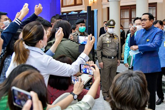 쁘라윳 짠오차 태국 총리가 9일(현지시간) 방콕에서 진행된 기자회견에서 난감한 질문을 피하기 위해 기자들을 향해 손소독제를 뿌리고 있다. 연합뉴스