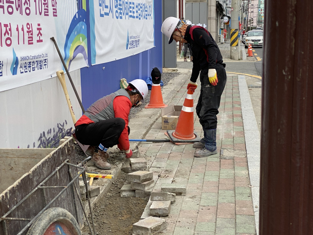 포항 득량지구 재건축 공사 현장 주변에 지반침하 현상이 일어나면서 지난 10일 시공사인 신원종합개발 측이 뒤틀린 보도블럭을 보수 공사하고 있다. 주민 제공