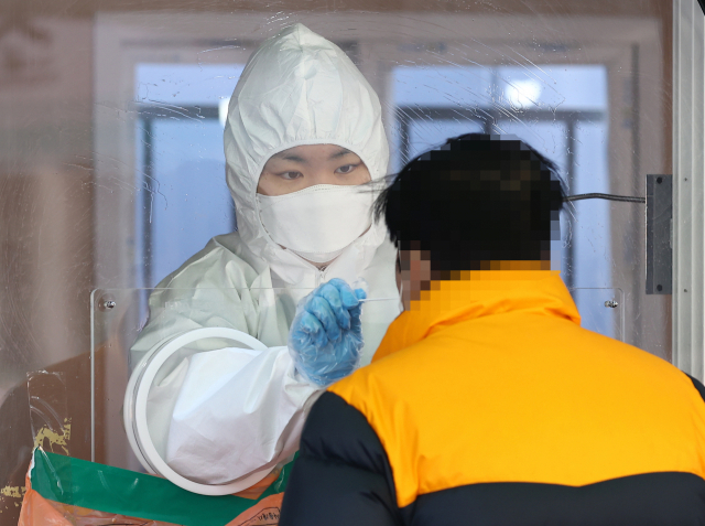 코로나19 신규 확진자 수가 415명을 기록한 27일 오전 서울역에 설치된 임시선별진료소에서 한 시민이 코로나19 검사를 받고 있다. 사진은 기사 내용과 관련 없음. 자료사진 연합뉴스