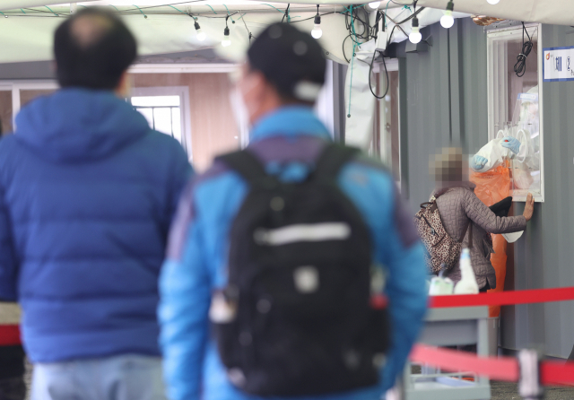 국내 신종 코로나바이러스 감염증(코로나19) 확산세가 이어지면서 닷새째 신규 확진자 수가 400명대를 기록한 13일 오전 서울역광장에 마련된 임시선별진료소에서 의료진이 검체를 채취하고 있다. 중앙방역대책본부는 이날 0시 기준으로 코로나19 신규 확진자가 490명 늘어 누적 9만5천176명이라고 밝혔다. 연합뉴스