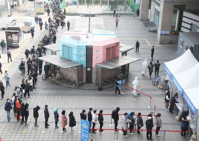 14일 오전 경기도 수원역 광장에 설치된 신종 코로나바이러스 감염증(코로나19) 임시선별진료소에 시민들과 경기도 내 외국인 근로자 코로나19 전수검사 행정명령에 따라 검사를 받으러 온 외국인 근로자들이 길게 줄을 서 있다. 사진은 기사내용과 관련 없음. 연합뉴스