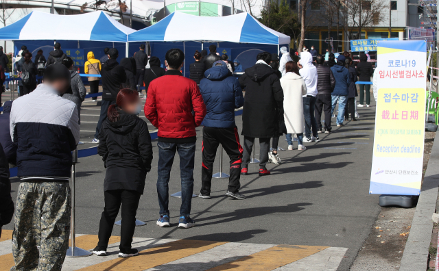 16일 오후 경기도 안산시 단원구 외국인주민지원본부 옆에 설치된 신종 코로나바이러스 감염증(코로나19) 임시선별검사소에 시민 및 경기도 내 외국인 근로자 코로나19 전수검사 행정명령에 따라 검사를 받으러 온 외국인 근로자들이 길게 줄을 서 있다. 연합뉴스