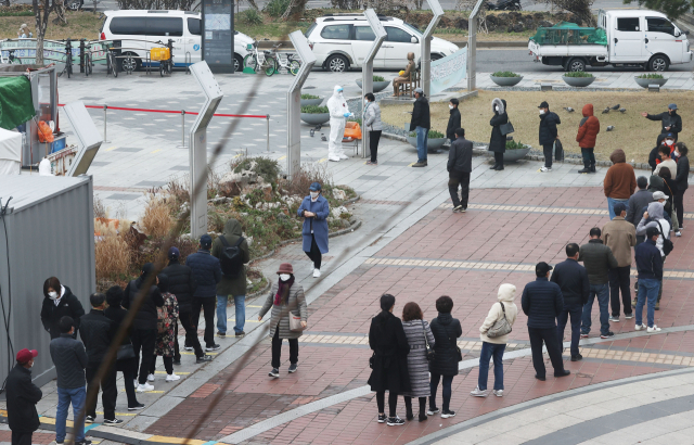 신종 코로나바이러스 감염증(코로나19) 신규 확진자가 닷새 연속 400명대를 기록한 21일 오전 서울 구로역광장에 마련된 임시 선별진료소 앞에 시민들과 외국인들이 검체 검사를 받기 위해 줄을 서 있다. 연합뉴스