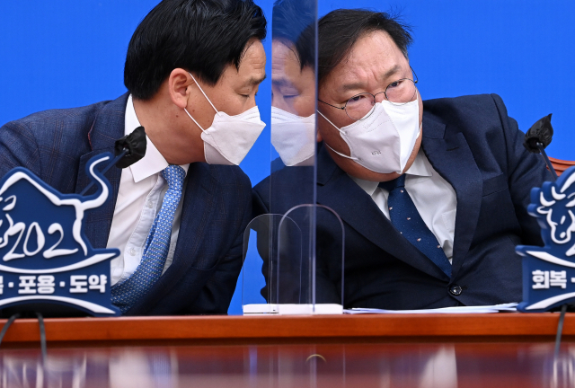 더불어민주당 김태년 당대표 직무대행 겸 원내대표가 23일 오전 서울 여의도 국회에서 열린 원내대책회의에서 발언을 마친 뒤 김영진 원내수석부대표로부터 서울시장 후보 야권 단일화 소식을 전해 듣고 있다. 연합뉴스