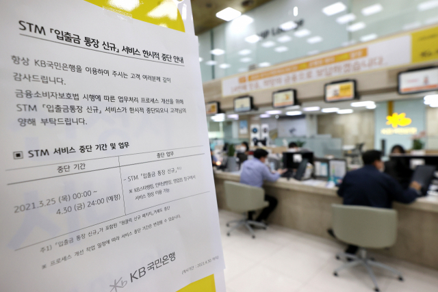 금융소비자보호법(금소법) 시행 첫 날인 25일 오후 서울 KB국민은행 여의도본점에 STM(스마트 텔러 머신) 입출금 통장 신규 서비스의 한시적 중단 관련 안내문이 붙어있다. 이날부터 주요 시중은행들은 비대면 상품 판매와 AI(인공지능) 서비스 등을 중단했다. KB국민은행은 다음 달 30일까지 STM에서 새로 입출금 통장을 만드는 서비스를 제공하지 않는다. 연합뉴스