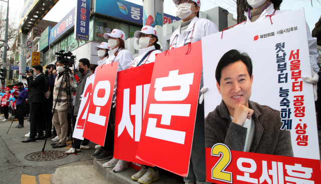 4·7재보궐선거 국민의힘 오세훈 서울시장 후보 운동원들이 29일 오후 서울 강북구 수유동 강북종합시장 입구에서 열린 김종인 중앙선대위원장 지원유세에서 연설을 듣고 있다. 연합뉴스