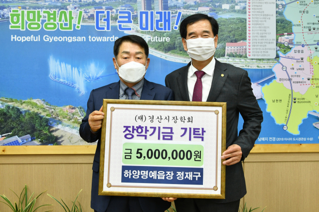 정재구 경산시 하양명예읍장(왼쪽)이 29일 (재)경산시장학회에 장학금 500만원을 기탁했다. 경산시 제공