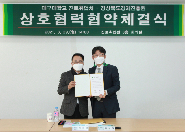 전창록(왼쪽) (재)경상북도경제진흥원장과 김영한 대구대 진로취업처장이 협약서를 들어보이고 있다. 대구대 제공