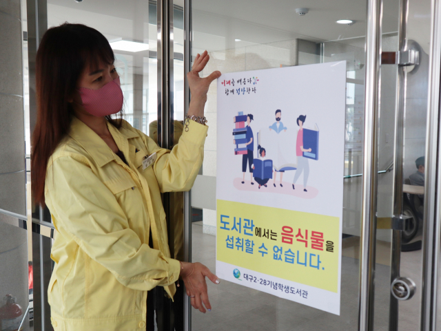 대구2·28기념학생도서관(관장 배호기) 북카페 입구에서 도서관 직원들이 음식물 섭취 금지라고 적힌 안내문을 붙이고 있다. 이를 비롯해 개편된 사회적 거리두기 기본 방역 수칙은 4일까지 계도기간을 거쳐 5일 자정부터 시행된다.