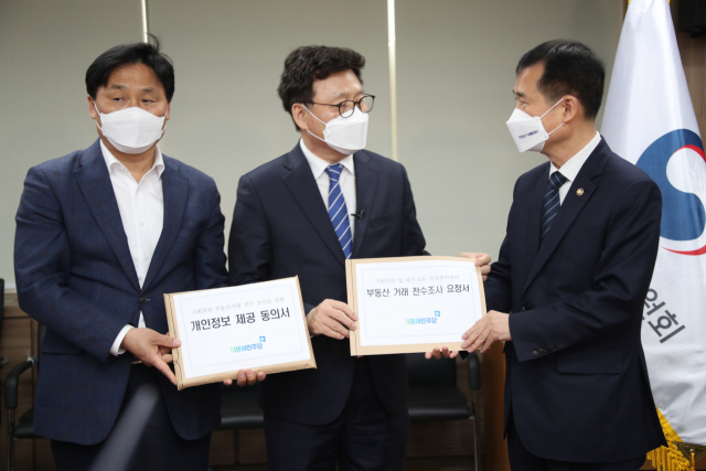 더불어민주당 박광온 사무총장(가운데)이 30일 오전 정부서울청사를 방문해 이건리 국민권익위원회 부위원장(오른쪽)에게 국회의원 및 가족의 부동산 거래 전수조사 요청서를 제출하고 있다. 연합뉴스