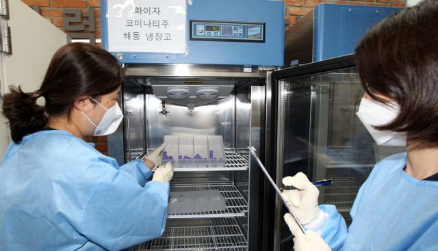 30일 서울 동작구 사당종합체육관에 마련된 동작구 코로나19 백신접종센터에서 관계자들이 다음 달 1일 75세 이상 관내 어르신들에게 하루 동안 접종할 화이자 백신 수량 점검을 마친 뒤 해동용 냉장고에 넣고 있다. [동작구청 제공] 연합뉴스