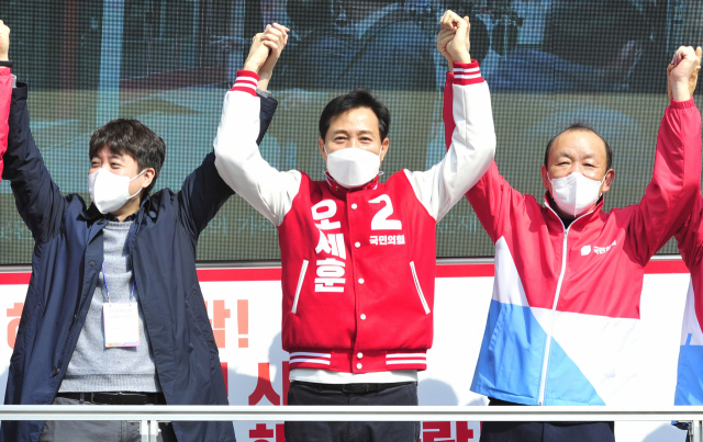 4·7 재보선 국민의힘 오세훈 서울시장 후보가 지난 25일 오전 서울 서대문구 유진상가 앞에서 선거유세를 마친 후 이준석 국민의힘 선거대책위원회 뉴미디어본부장, 송주범 당원협의회운영위원장과 손을 맞잡아 들어보이고 있다. 연합뉴스