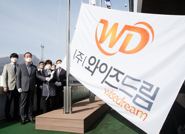 구미시 4월 이달의 기업으로 선정된 ㈜와이즈드림 전경아(왼쪽 세 번째) 대표를 비롯한 회사 관계자, 장세용 구미시장 등이 구미시청 게양대에서 회사기 게양식을 하고 있다. 구미시 제공