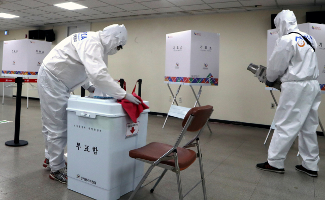 4.7 부산시장 보궐선거 사전투표를 하루 앞둔 1일 오후 부산 연제구 연산6동 행정복지센터에 마련된 사전투표소에서 방역 요원이 코로나19 대응 소독작업을 벌이고 있다. 연합뉴스