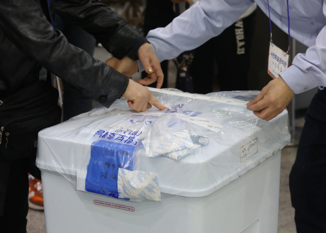 4·7재보궐선거 사전투표가 종료된 3일 오후 서울역에 마련된 남영동 사전투표소에서 서울시선관위 관계자들이 관내 투표함을 밀봉하고 있다. 연합뉴스