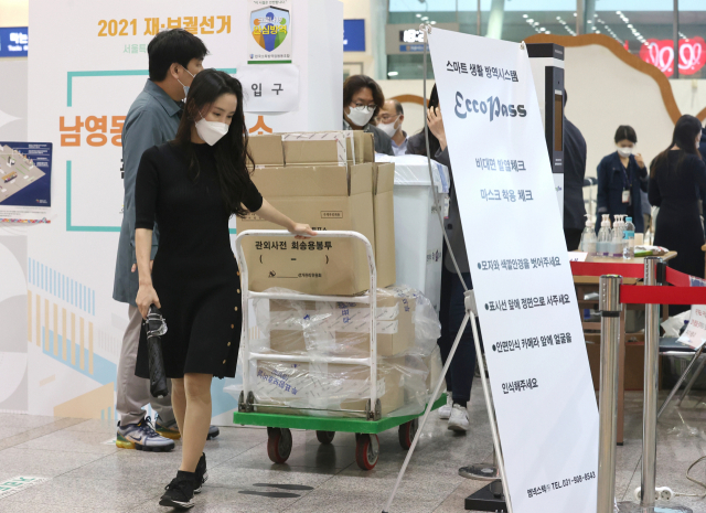 4·7재보궐선거 사전투표가 종료된 3일 오후 서울역에 마련된 남영동 사전투표소에서 서울시선관위 관계자들이 투표함을 옮기고 있다. 연합뉴스