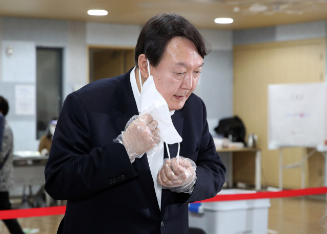 윤석열 전 검찰총장이 4·7 서울시장 보궐선거 사전투표 첫날인 2일 서울 서대문구 남가좌1동 주민센터에 마련된 사전투표소에서 마스크를 벗어 본인 인증을 하고 있다. 연합뉴스