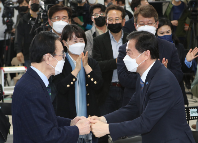 7일 오후 김영춘 더불어민주당 부산시장 후보(오른쪽)가 4·7 부산시장 보궐선거 출구조사 결과를 보러 부산 부산진구 선거사무소 4층에 입장하며 문정수 전 부산시장과 주먹악수를 하고 있다. 연합뉴스