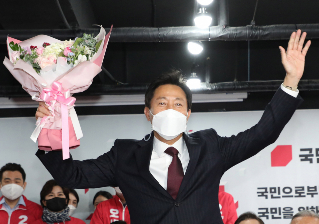 4·7 재보궐 선거에서 서울시장 당선이 확실해진 국민의힘 오세훈 후보가 8일 자정께 서울 여의도 당사 개표상황실에서 꽃다발을 받고 기뻐하고 있다. 연합뉴스