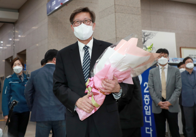 박형준 부산시장이 8일 오전 부산시청으로 첫 출근하며 직원으로부터 꽃다발을 받고 있다. 연합뉴스