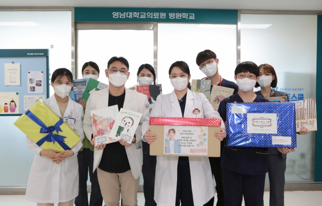 영남대학교의료원 병원학교 의료진들이 8일 배우 이준기의 일본 팬들이 기부한 어린이책을 들고 기념촬영을 하고 있다.