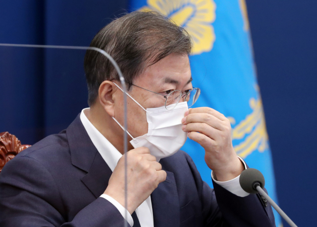 문재인 대통령이 5일 청와대에서 열린 수석·보좌관 회의에서 발언을 마치고 마스크를 착용하고 있다. 연합뉴스