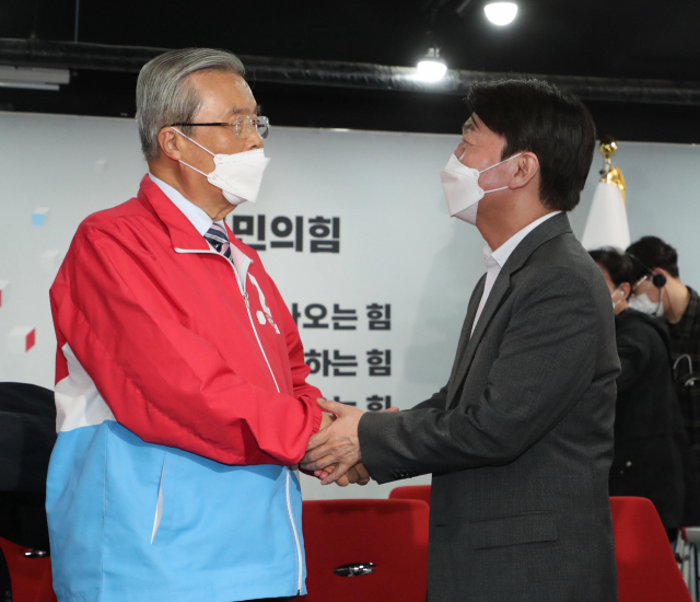 4·7 재보궐 선거에서 국민의힘 오세훈 서울시장 후보의 당선이 확실해진 8일 자정께 서울 여의도 당사 국민의힘 개표상황실에서 김종인 전 비상대책위원장(왼쪽)과 국민의당 안철수 대표가 손을 맞잡고 있다. 연합뉴스