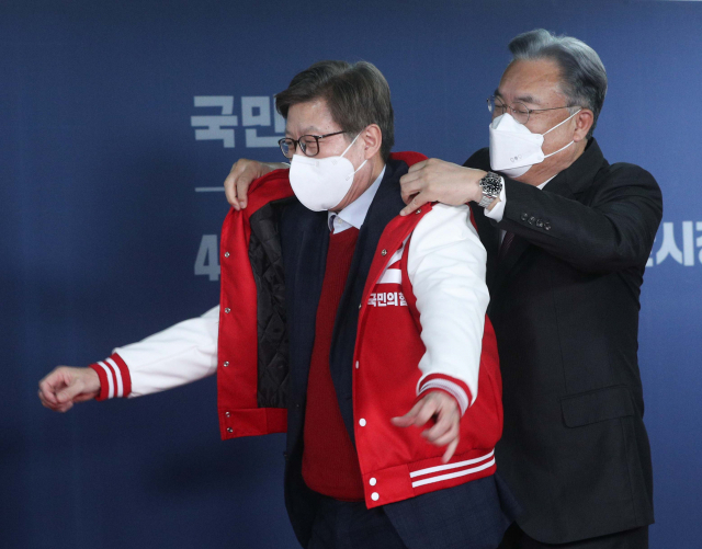 국민의힘 부산시장 후보로 선출된 박형준 후보(왼쪽)가 4일 오전 서울 여의도 국민의힘 중앙당사에서 열린 서울·부산시장 후보 경선 결과 발표회에서 당 점퍼를 입고 있다. 오른쪽은 정진석 공천관리위원장. 연합뉴스