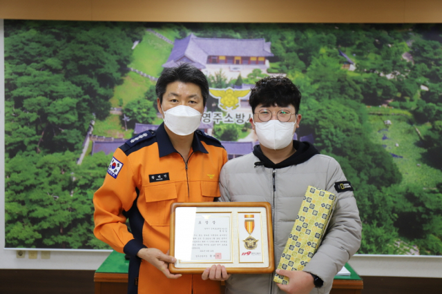 황정섭(오른쪽) 씨가 화재 진압 유공 표창을 받았다. 영주소방서 제공