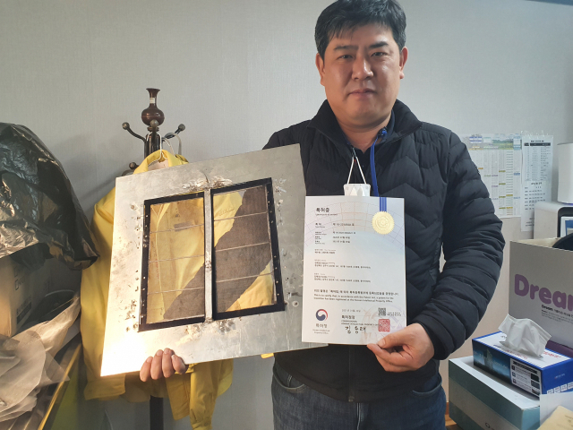 국내 처음으로 도심속 모기와 해충을 획기적으로 줄일수 있는 배수용 방충망을 발명한 상주시청 공무원 김해성 씨가 특허청으로부터 교부받은 특허증과 발명품을 들고 포즈를 취하고 있다. 고도현 기자