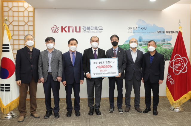 퇴임을 앞둔 경북대 교직원들이 홍원화(왼쪽에서 네번째) 총장을 만나 발전기금 1천만원을 전달한 뒤 기념촬영을 하고 있다. 경북대 제공