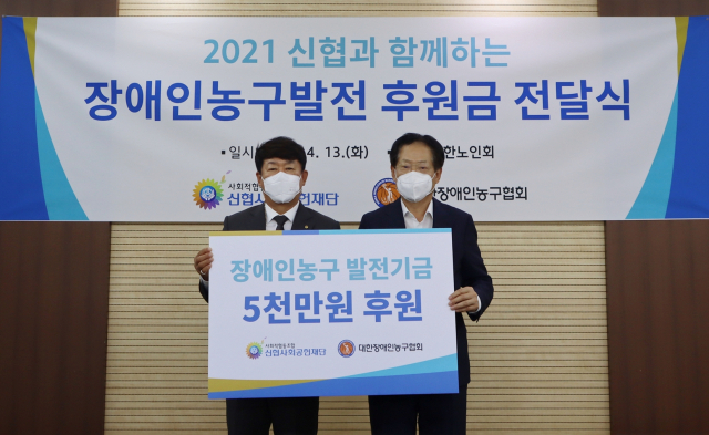 김윤식 신협사회공헌재단 이사장(왼쪽)이 13일 대한노인회에서 장애인 농구 저변 확대를 위한 후원금을 대한장애인농구협회에 전달하고 있다. 신협 제공