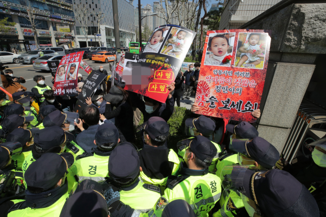 16개월 된 입양 딸 정인 양을 학대해 숨지게 한 혐의를 받는 양부모의 결심 공판이 열린 14일 오후 서울 양천구 서울남부지방법원 입구에서 시민들이 양모가 탑승한 것으로 보이는 호송차를 향해 팻말을 들고 항의하고 있다. 연합뉴스