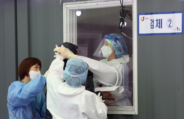 국내 신종 코로나바이러스 감염증(코로나19) 확산세가 갈수록 거세지는 가운데 14일 오후 서울역광장에 마련된 임시선별진료소에서 의료진이 검체를 채취하고 있다. 중앙방역대책본부는 이날 0시 기준으로 코로나19 신규 확진자가 731명 늘어 누적 11만1천419명이라고 밝혔다. 연합뉴스
