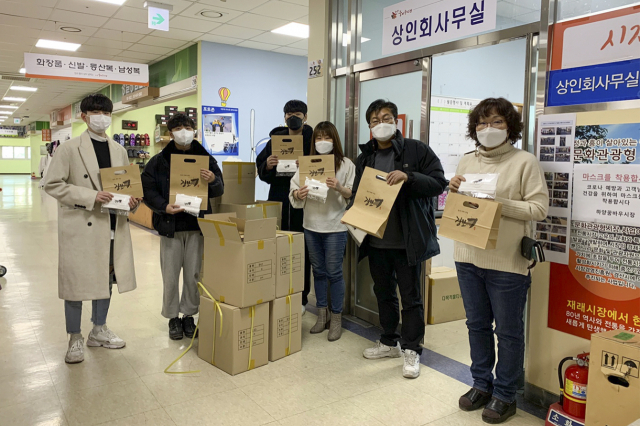 경일대 학생들이 하양꿈바우시장 상인회에 디자인 제품을 배포하고 기념사진을 찍고 있다. 경일대 제공