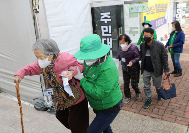 경북 의성군의 백신 접종이 시작된 첫 날 어르신들이 보호자와 자원봉사자들의 부축을 받아 예방접종센터로 들어가고 있다. 의성군 제공