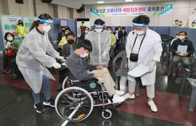14일 대구 달성군 코로나19 예방접종센터인 달성유통센터에서 열린 백신 접종 모의훈련에서 의료진이 이상 반응자를 응급처치실로 옮기고 있다. 달성군 백신 접종은 22일부터 진행될 예정이다. 성일권 기자 sungig@imaeil.com