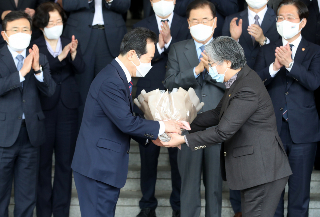 정세균 국무총리가 16일 오후 서울 종로구 정부서울청사 별관에서 이임식을 마치고 정은경 질병관리청장에게 꽃다발을 받고 있다. 연합뉴스