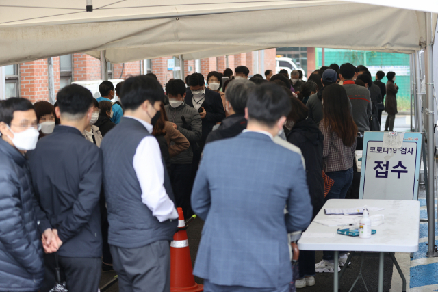 법무부에서 신종 코로나바이러스 감염증(코로나19) 확진자가 발생한 16일 오전 경기도 과천 법무부 청사 인근에 위치한 과천보건소 선별진료소에서 시민 및 법무부 직원들이 줄을 서 있다. 연합뉴스