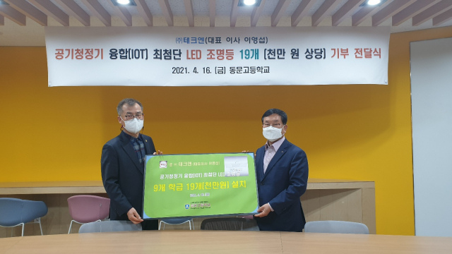 이영섭(오른쪽) ㈜)테크엔 대표가 대구 동문고에 공기청정 기능이 장착된 LED 조명등을 기부하고 있다. ㈜테크엔 제공